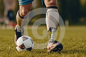 A man on prosthetic legs running and playing football on sports field. A man on prosthetic legs doing sport