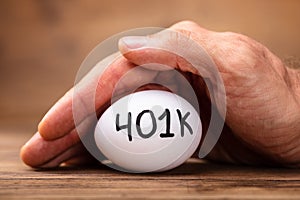 Man Protecting 401k White Egg