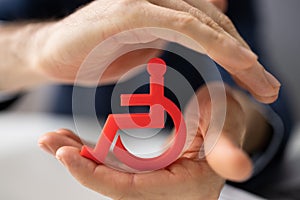 Man Protecting Cubic Block With Disabled Handicap Icon