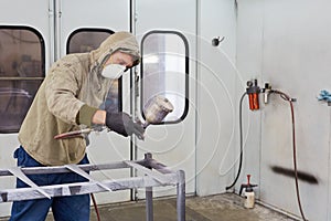 Man in protective clothes paints car details