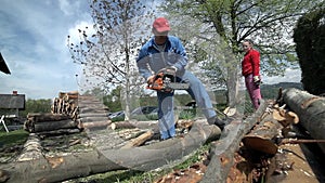 Man in protective clothes sawing timber