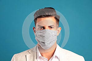 Man in protective face mask on blue background