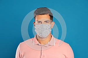 Man in protective face mask on blue background