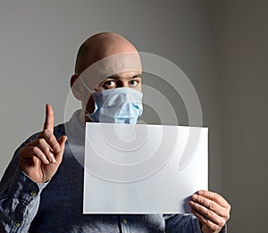 Man in protective face mask with white blank sheet poster mockup