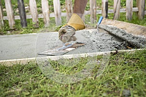 Man with protective gloves levelling the surface of a concrete p