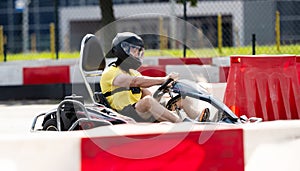 Man In Protective Helmet Driving Go-Kart By Racing Track