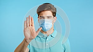 Man in protective mask disapproving with NO hand sign gesture. Denying, rejecting, disagree, portrait of guy or student