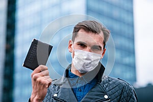 Man in a protective mask showing his passport