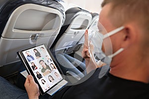 Man in protective medical mask conducts a remote business online conference via tablet while in transport