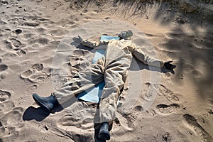 man in protective suit, mask on sand