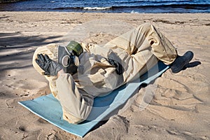man in protective suit, mask on sand