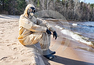 man in protective suit, mask on sand