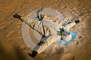 Man in protective suit, mask on sand