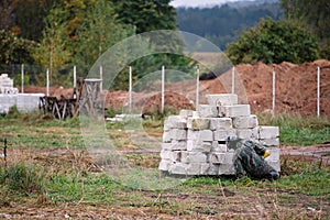 Man in protective uniform plays paintball, hides behind  fence