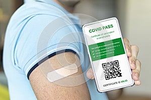 man proves that he is vaccinated by showing a shoulder with a firmware and an electronic certificate of vaccination with