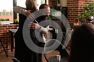 Man and psychologist hugging after sharing addiction progress with aa meeting group photo