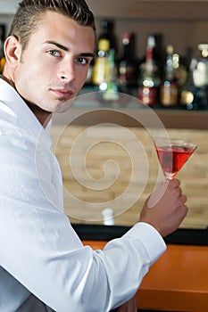 Man in a pub with red martini