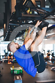 Man pulling his body up on the rig at the gym.