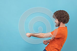 Man pulling invisible rope, showing his persistence and leadership qualities.