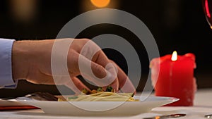 Man pulling long hair out of plate with spaghetti, disgust unsanitary conditions