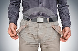 Man pulling out empty pockets - poor people concept