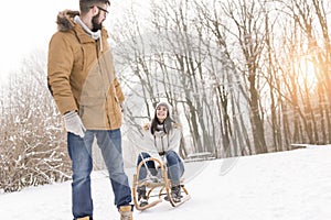 Man pulling woman on a sleigh