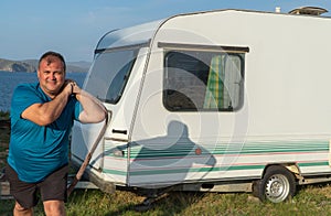 Man pulls a tourist trailer with a rope. concept of outdoor recreation