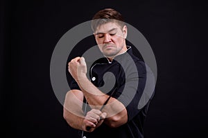 A man pumped up put a knife to his hand on a black background