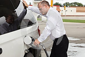 Man pumping gas into vehicle.