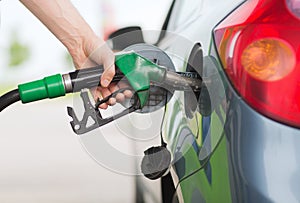 Man pumping gasoline fuel in car at gas station photo