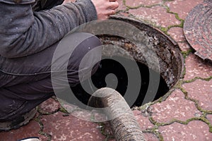 Man pumping sewage from the drain hole