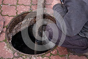 Man pumping sewage from the drain hole