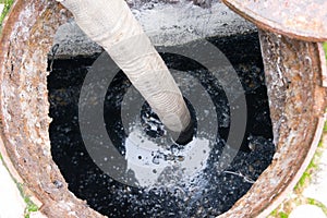 Man pumping sewage from the hole