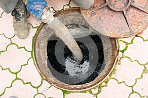 Man pumping sewage from the hole