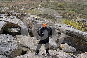 Man in a pumpkin mask in the mountains.