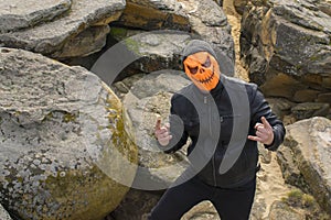 Man in a pumpkin mask in the mountains.