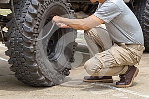 Man pumps a offroad car wheel with a compressor