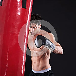 Man, punching bag and challenge with fitness, training and fighter with gloves and wellness with cardio. Boxer, practice