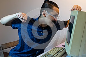 A man punching a old computer monitor