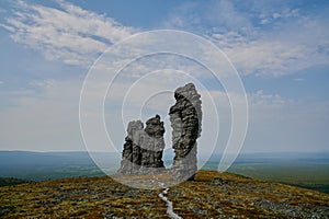 Man-Pupu-Ner weathering pillars in the center with a path made of stone against the background of the tundra