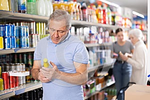 Man purchaser choosing cool drink in supermarket