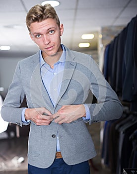 Man purchaser trying jacket in the dress shop