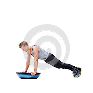 Man, push up for exercise and balance, bosu ball for core training and muscle in workout on white background. Fitness