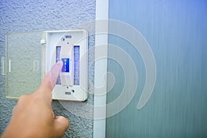 Man push the white exit button on electronic panel. staff push exit button to open door