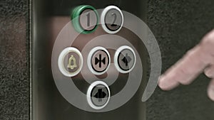 Man pushes a button opening elevator doors. Close up