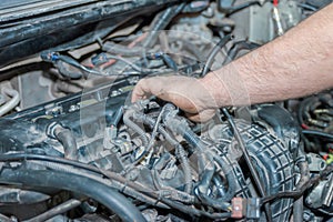 The man pushes the cooling pipes away from the engine