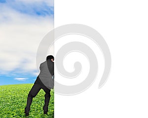 Man pushing away white empty wall