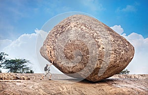 Man pushing a big stone