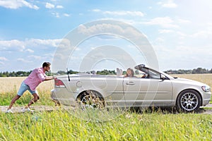 Man pushing broken down car