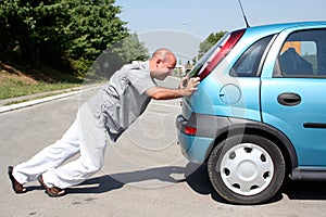 Man pushing a car photo